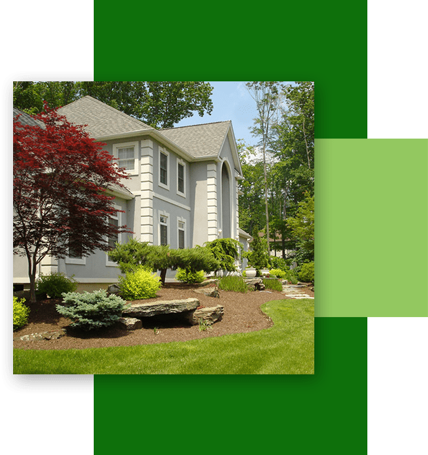 A house with green grass and trees in the background.